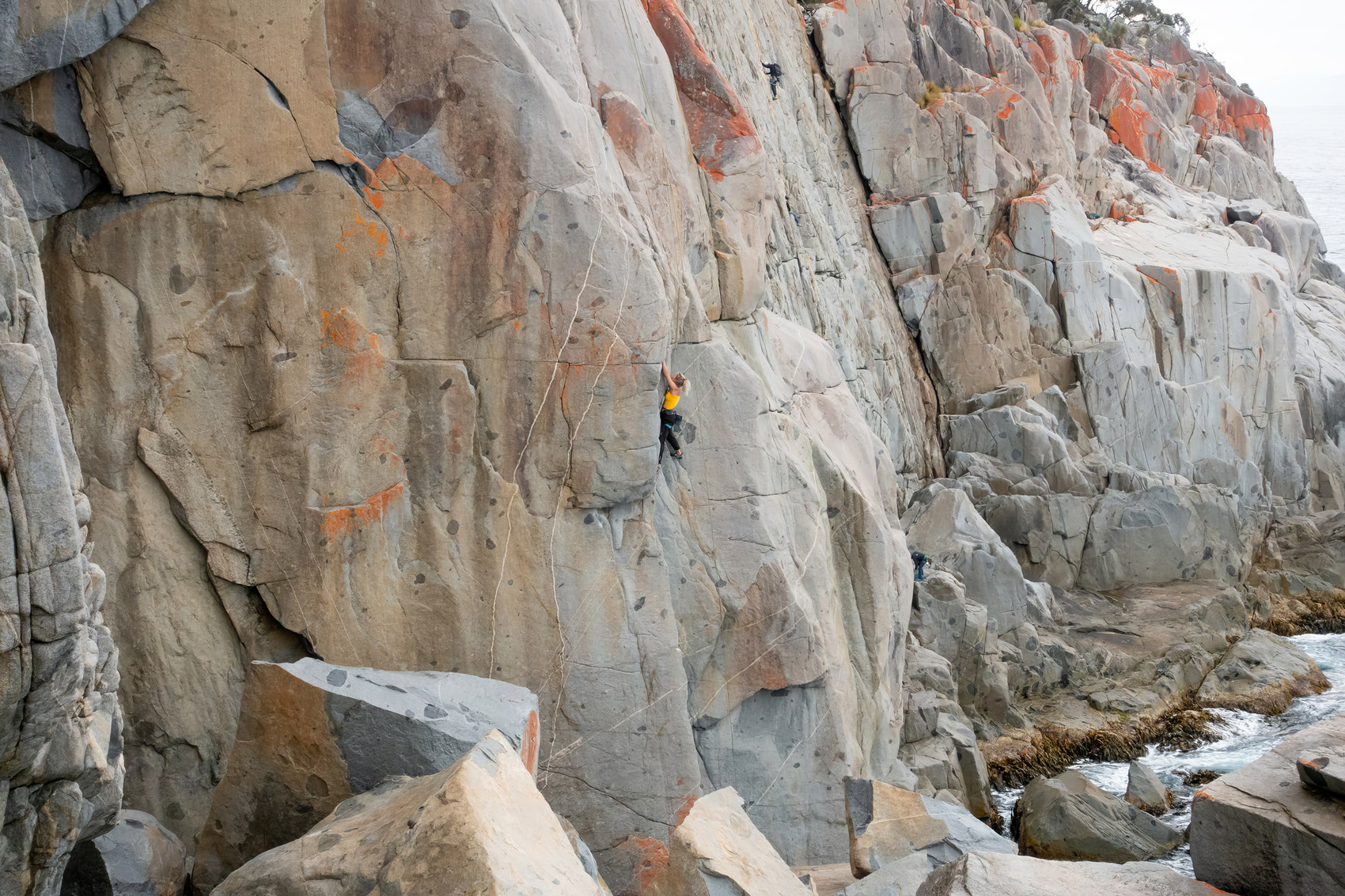 Climber on granite coastal cliffs